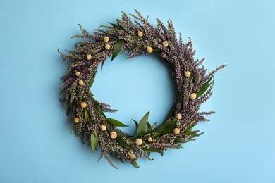Beautiful heather wreath on light blue background, top view. Autumnal flowers