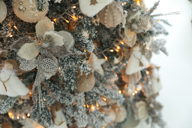 Beautiful Christmas tree on light background, closeup. Festive interior decoration