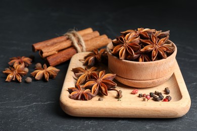 Photo of Aromatic anise stars and spices on black table