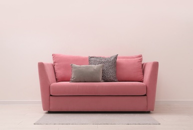 Simple room interior with comfortable pink sofa, space for text