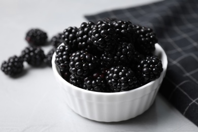 Delicious fresh ripe blackberries in bowl on table, closeup