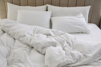Many soft pillows and blanket on large comfortable bed