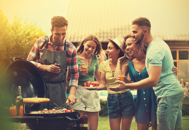 Group of friends with drinks near barbecue grill outdoors on sunny day