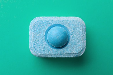 Photo of Water softener tablet on turquoise background, top view
