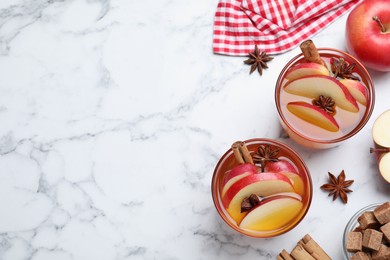 Aromatic hot mulled cider on white marble table, flat lay. Space for text