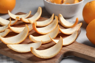 Photo of Many orange peels preparing for drying on grey table, closeup