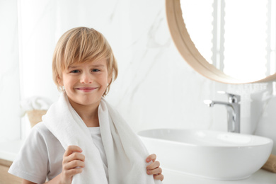Cute little boy with towel in bathroom. Space for text