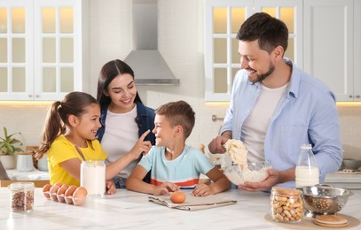 Happy family cooking together at table in kitchen. Adoption concept