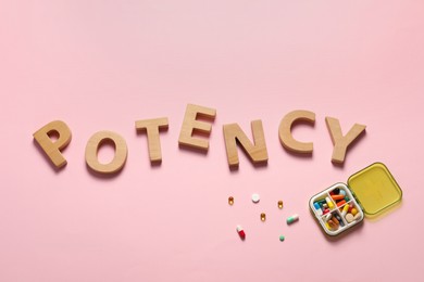 Word Potency made of wooden letters and pills on light pink background, flat lay