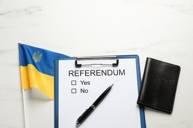 Referendum ballot with passport, pen and flag of Ukraine on white marble table, flat lay
