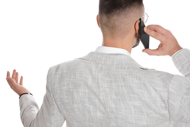 Businessman talking on mobile phone against white background, closeup