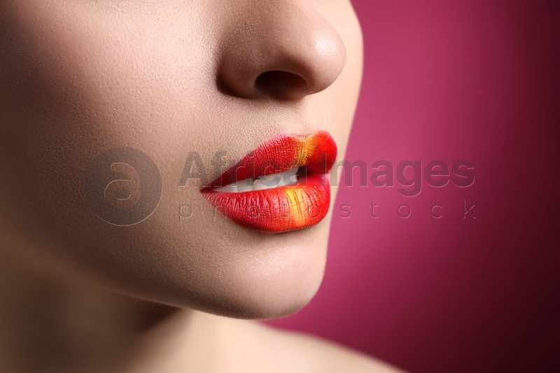 Young woman with beautiful lips makeup on pink background, closeup. Space for text