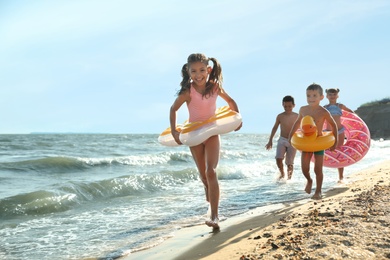 Cute children enjoying sunny day at beach. Summer camp