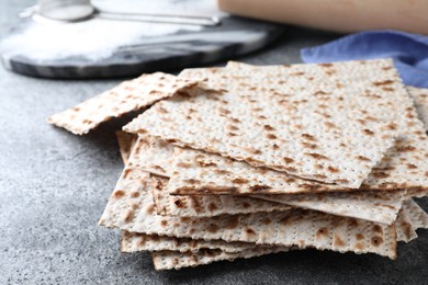 Stack of traditional matzos on grey table, closeup