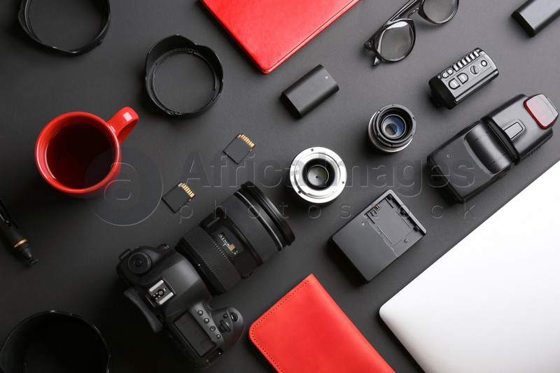 Flat lay composition with professional photographer equipment on dark background