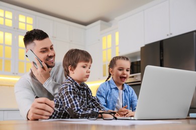 Photo of Happy man combining parenting and work at home