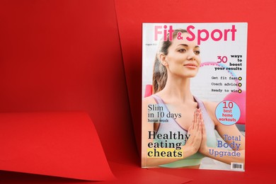 Modern printed sports magazine on red background, space for text
