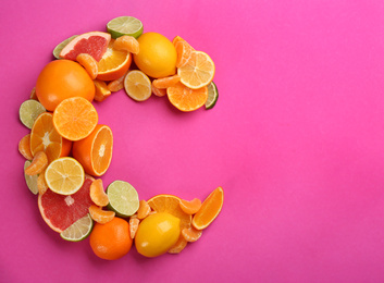 Photo of Letter C made with citrus fruits on pink background as vitamin representation, flat lay. Space for text