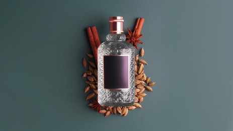 Photo of Bottle of luxurious perfume and spices on color background, top view