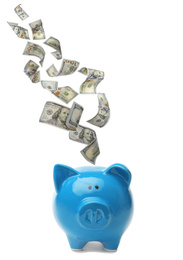 Dollars falling into blue piggy bank on white background 