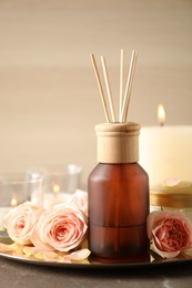 Photo of Spa composition with aroma oil and roses on grey table, closeup