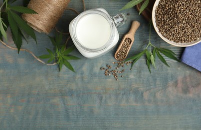 Flat lay composition with fresh hemp milk on light blue wooden table. Space for text