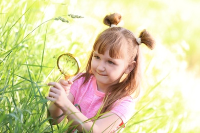 Little girl exploring plant outdoors. Summer camp