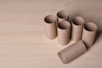 Empty toilet paper rolls and space for text on wooden background
