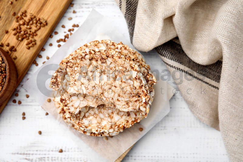 Photo of Crunchy buckwheat cakes on white wooden table, flat lay