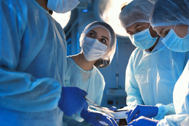 Photo of Team of professional surgeons performing operation in clinic