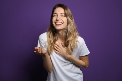 Photo of Cheerful young woman laughing on violet background