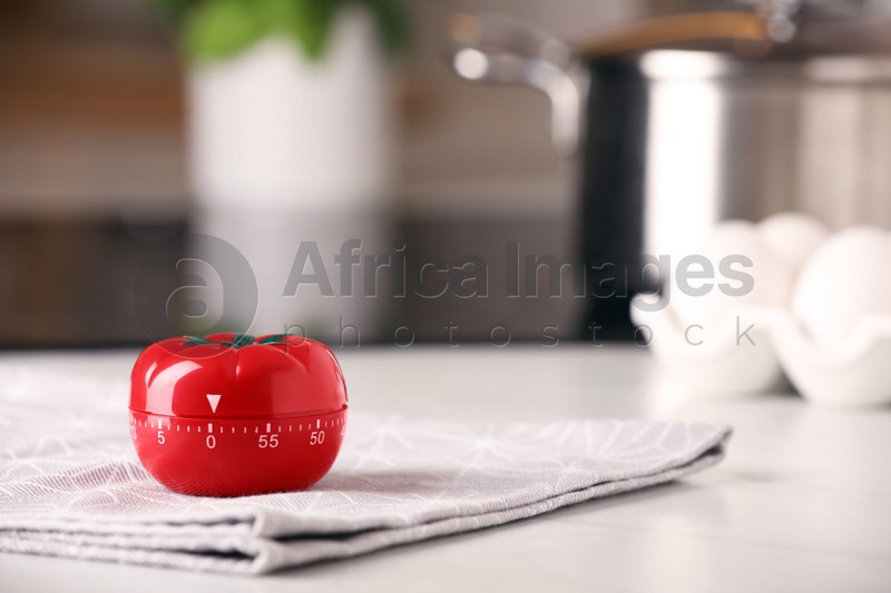 Kitchen timer in shape of tomato on white table indoors. Space for text