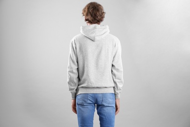 Photo of Man in hoodie sweater on light background. Space for design