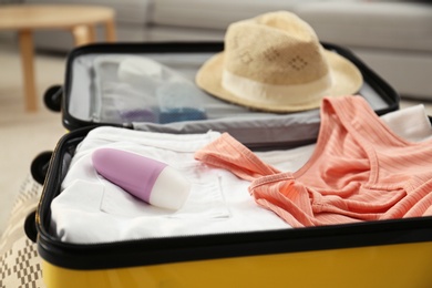 Suitcase with deodorant and clothes at home