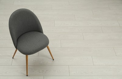 Stylish grey chair on floor. Space for text