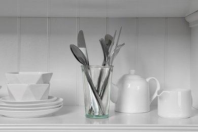 White shelving unit with dishware and cutlery