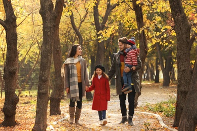 Photo of Happy family with children spending time together in park. Autumn walk
