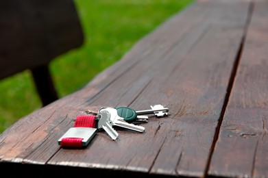 Keys forgotten on wooden bench outdoors. Lost and found