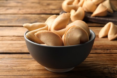 Tasty fortune cookies with predictions on wooden table, closeup