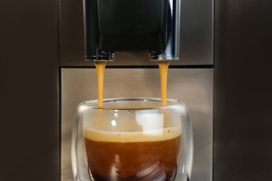 Espresso machine pouring coffee into glass, closeup