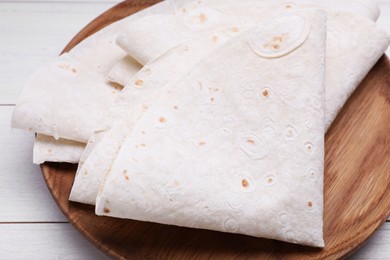 Photo of Delicious folded Armenian lavash on white wooden table, closeup