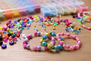 Beautiful handmade beaded bracelets and supplies on wooden table