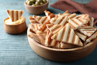 Delicious pita chips on blue wooden table, closeup