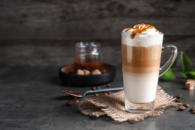 Glass cup with delicious caramel frappe on table