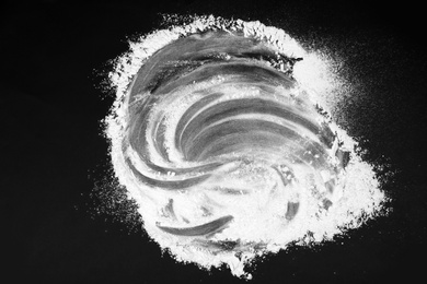 Scattered flour on black table, top view