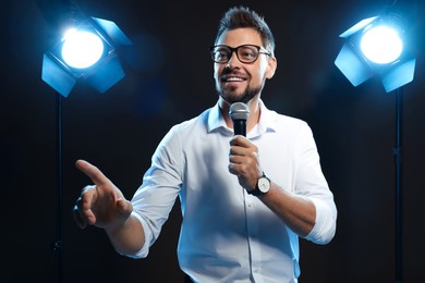 Motivational speaker with microphone performing on stage