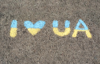 Photo of Inscription I love Ukraine drawn by blue and yellow chalk on asphalt
