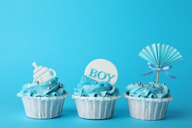 Photo of Baby shower cupcakes with toppers on light blue background