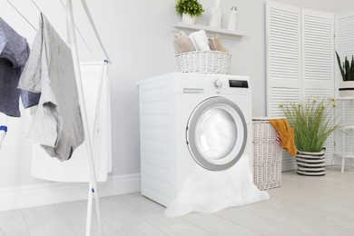 Foam coming out from broken washing machine during laundering in room