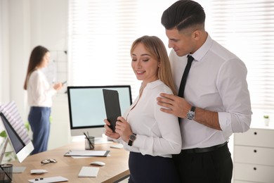Man flirting with his colleague in office. Space for text